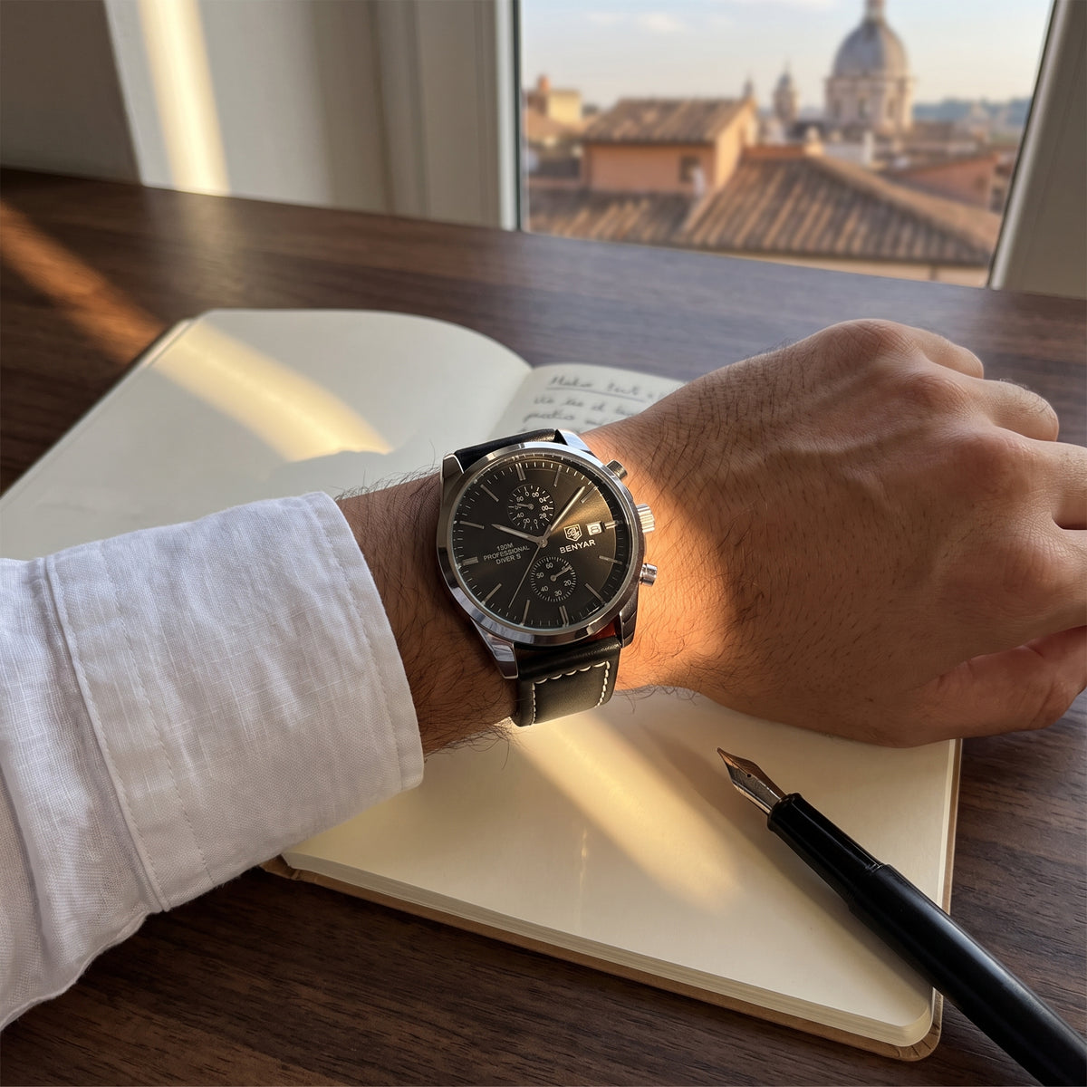 Livorno with black dial worn on the wrist while writing in a notebook with a fountain pen