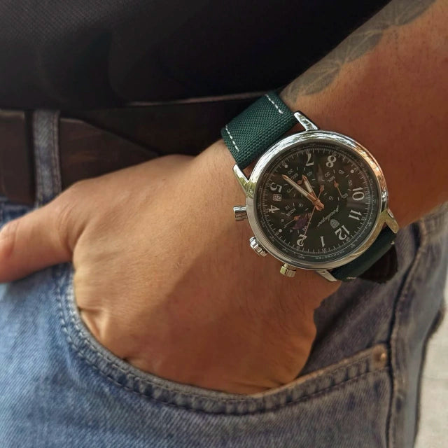 Man wearing the Lunario chronograph with green nylon strap, hand resting in denim pocket