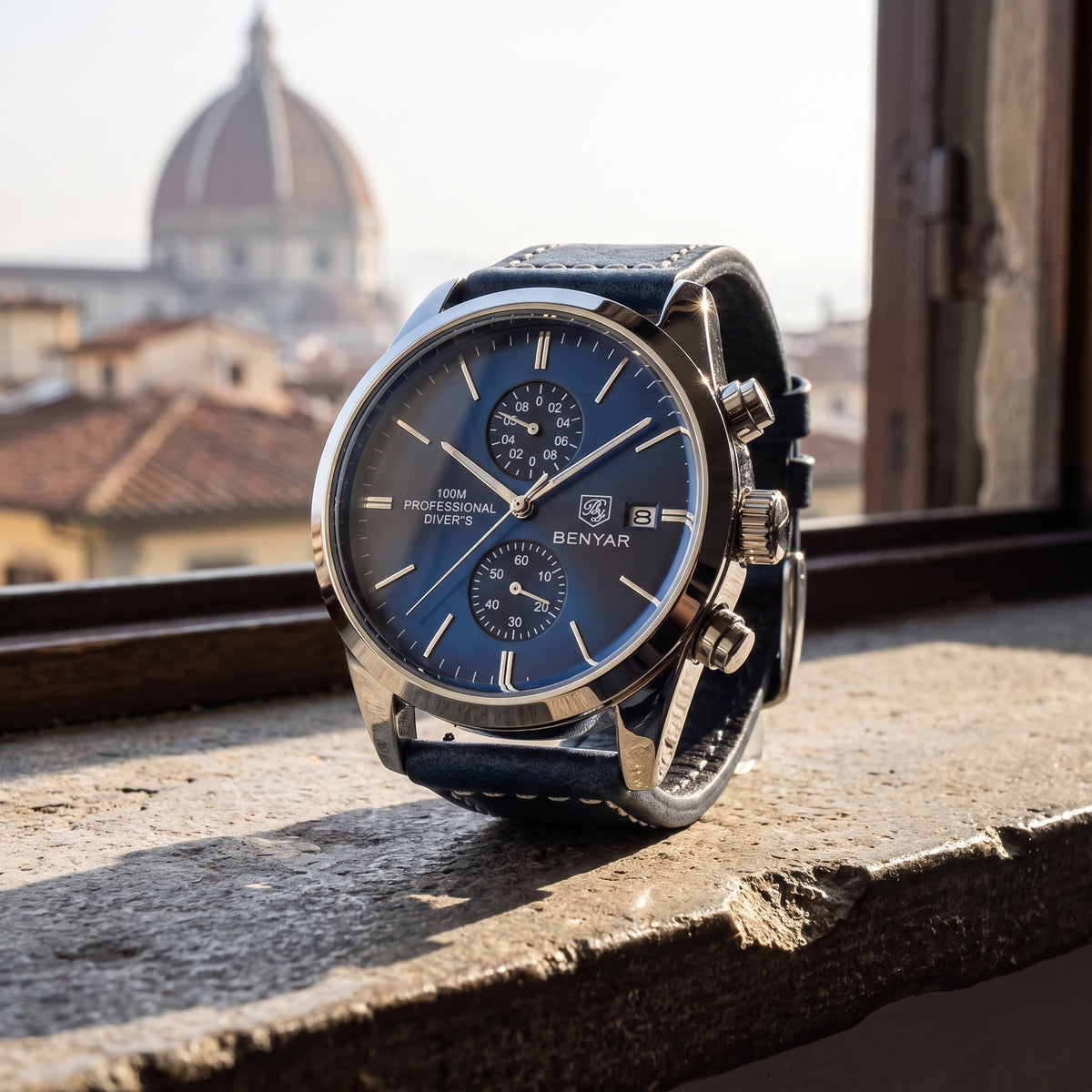 Livorno with deep blue dial and navy leather strap on a stone windowsill overlooking terracotta rooftops