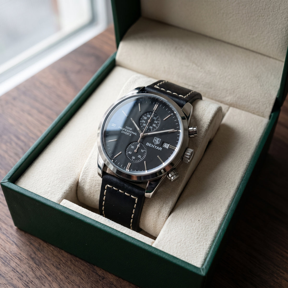 Livorno with silver-tone case, black dial and black leather strap in an open green presentation box