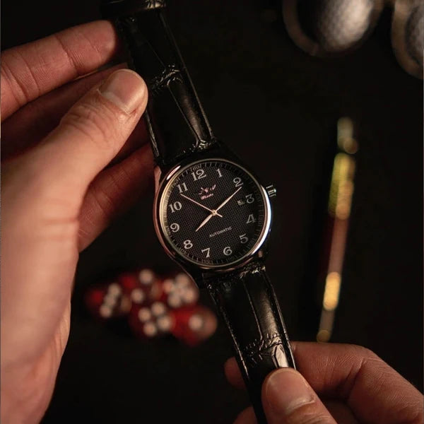 Lorenzo black dial watch held in hand under warm evening light