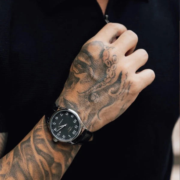 Lorenzo black dial watch worn on the wrist with a black knit shirt