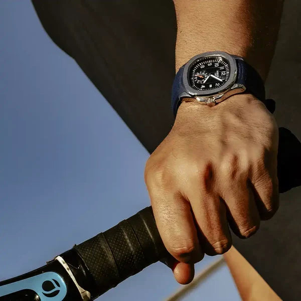 Portofino sport watch with blue strap worn on the wrist, hand resting on bicycle handlebars