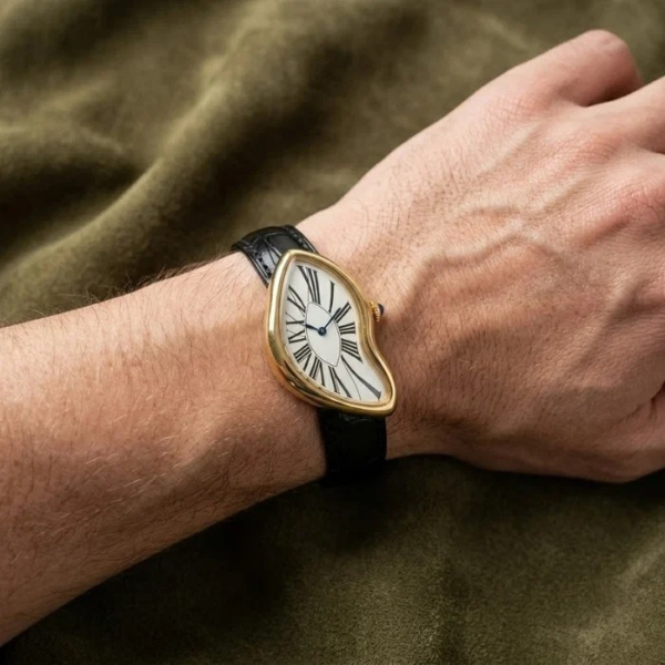 Positano gold-tone watch worn on the wrist, sculpted asymmetric case