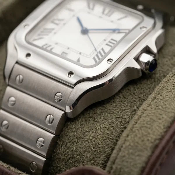 Macro of the Santtus steel case flank, blue cabochon crown and screwed bracelet links on green suede