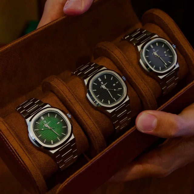 Green, black and blue Tremezzo watches side by side in a brown suede watch roll